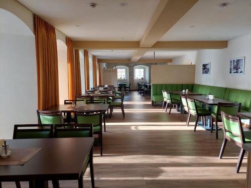 an empty dining room with tables and chairs at Zinzendorfhaus Neudietendorf in Neudietendorf