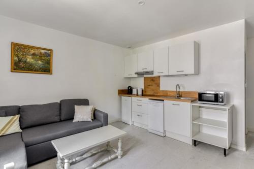 un salon avec un canapé et une cuisine dans l'établissement Le Bambou Wifi Proche des pontons et du Doul, à Peyriac-de-Mer