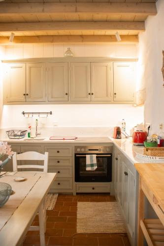 a kitchen with white cabinets and a stove top oven at Patmos Traditional House Chora near the Monastery in Patmos
