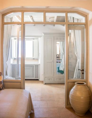 a room with a large glass door and a vase at Patmos Traditional House Chora near the Monastery in Patmos