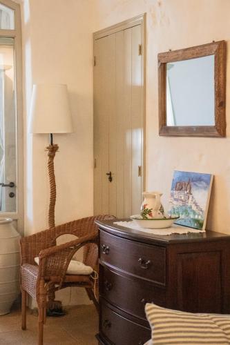 a room with a dresser and a lamp and a chair at Patmos Traditional House Chora near the Monastery in Patmos
