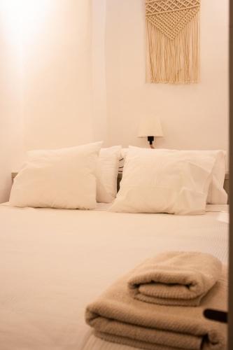 a white bed with white pillows and a lamp at Patmos Traditional House Chora near the Monastery in Patmos
