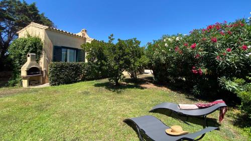 a garden with two benches and a house at Villa la Bonaccia in La Maddalena