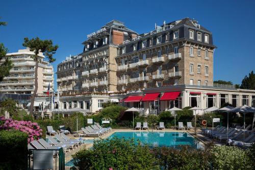 un hôtel avec une piscine devant un immeuble dans l'établissement Hôtel Barrière Le Royal La Baule, à La Baule