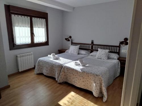 a bedroom with two beds and a window at Pensión Casa Morán in Benia