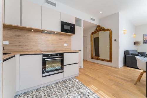 une cuisine avec des placards blancs et une cheminée dans l'établissement Charmant Appartement pour 4 au Cœur de Bordeaux, à Bordeaux