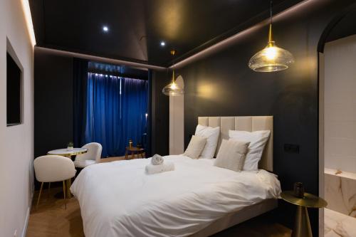 a bedroom with a large white bed and a table at Luxury Suite Romantic Getaway with Jacuzzi in Castres
