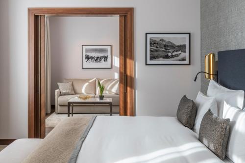 a bedroom with a bed and a living room at Grand Hotel des Bains Kempinski in St. Moritz