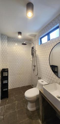a bathroom with a toilet and a sink and a mirror at Kamalia Villas in Kampung Penarik