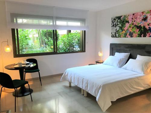 une chambre avec un lit, une table et une fenêtre dans l'établissement Agence AICI - Appartements Gray d'Albion, à Cannes