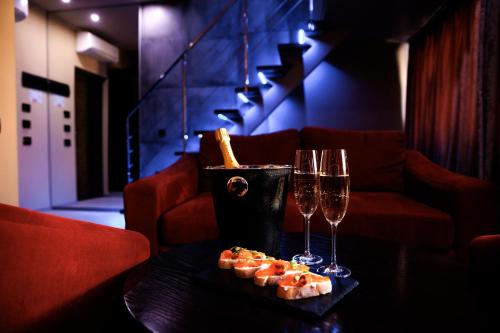 a table with two wine glasses and food on it at LH Hotel&SPA in Lviv