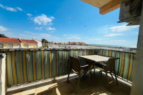 un balcon avec une table et des chaises et une vue sur la plage dans l'établissement Appartement les pieds dans l'eau Terrasse Mer, à Fleury