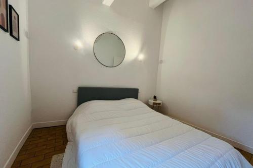une chambre avec un lit avec un miroir au mur dans l'établissement L'Horreum Appartement proche des Halles Wifi, à Narbonne