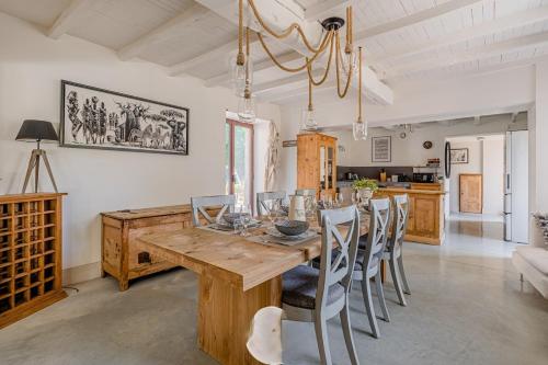 une salle à manger avec une table et des chaises en bois dans l'établissement Completely renovated old farmhouse in Drome, à Saint-Bonnet-de-Valclérieux