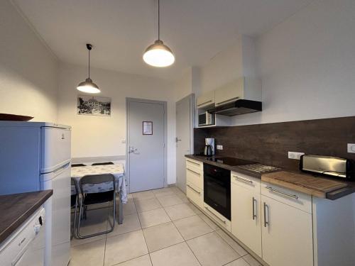 - une cuisine avec des appareils électroménagers blancs et une table dans l'établissement Maison confortable à Villard-de-Lans - 8 couchages, WiFi, parking gratuit, proche des pistes et du centre. - FR-1-548-5, à Villard-de-Lans