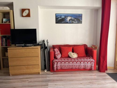 un salon avec un canapé rouge et une télévision dans l'établissement Appartement Pratique avec Balcon et Garage Privatif à Villard-de-Lans - FR-1-548-10, à Villard-de-Lans