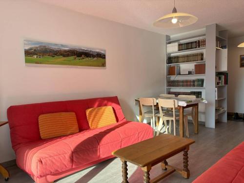 un salon avec un canapé rouge et une table dans l'établissement Appartement cosy, balcon sud, 2 chambres, parking gratuit à 10 min du centre et proche ski ! - FR-1-548-4, à Villard-de-Lans
