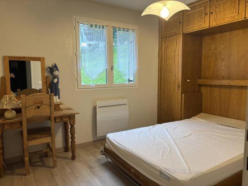 ein Schlafzimmer mit Bett, Schreibtisch und Fenster in der Unterkunft Appartement cosy, balcon sud, 2 chambres, parking gratuit à 10 min du centre et proche ski ! - FR-1-548-4 in Villard-de-Lans