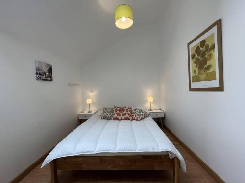 a bedroom with a bed with two lamps on two sides at Appartement fonctionnel avec balcon, à 10 min du centre, parking gratuit, idéal pour 5 personnes - FR-1-548-3 in Villard-de-Lans