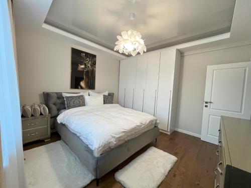 a bedroom with a bed and a chandelier at COLLINE Rezidențial in Rediu