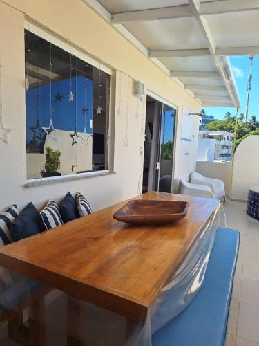 a wooden table with a bowl on top of it at Cobertura Duplex Na Praia Dos Milionários in Ilhéus