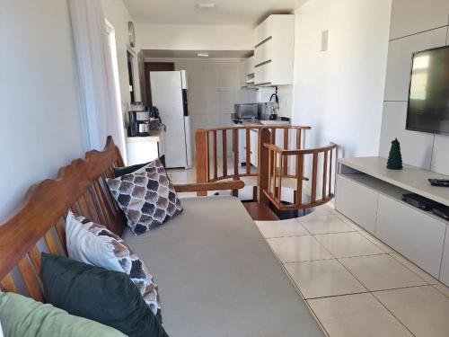 a living room with a couch and a kitchen at Cobertura Duplex Na Praia Dos Milionários in Ilhéus