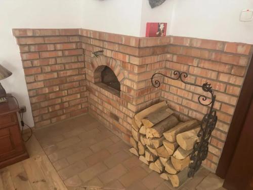 a brick fireplace with a pile of fire wood at Agroturystyka UL in Nowe Worowo