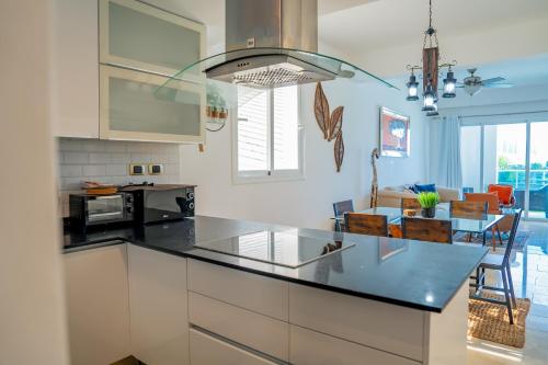a kitchen with white cabinets and a black counter top at Xeliter Cana Rock Punta Cana in Punta Cana
