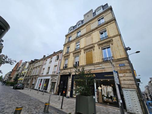 un grand bâtiment dans une rue de la ville avec un magasin dans l'établissement Refuge Urbain - Idéal pour familles & amis - Calme en plein centre-ville - Wifi Haut Débit - Netflix - Machine à laver - Gare, Cathédrale de Reims, Commerces, Restaurants & Transports en commun accessibles à pied en moins de 10 minutes, à Reims