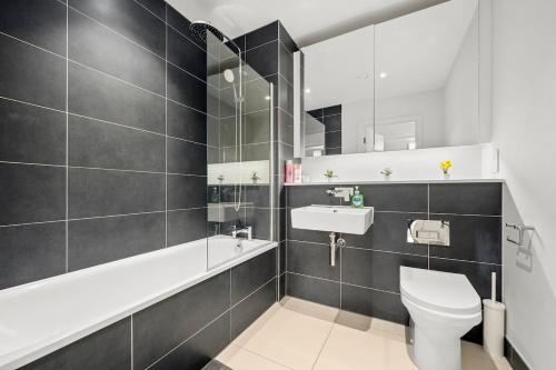 a bathroom with a white toilet and a sink at Modern Highrise Luxury Apartment in Manchester