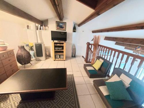 un salon avec un canapé et une télévision dans l'établissement Appartement 2 pièces mezzanine climatisé avec piscine et parking privé à Marseillan - FR-1-326-789, à Marseillan