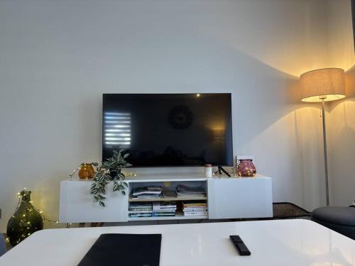 un salon avec une télévision sur un centre de divertissement blanc dans l'établissement Appartement Confortable avec Terrasse à 5 Min du Centre, Navette Ski Gratuite ! - FR-1-548-34, à Villard-de-Lans