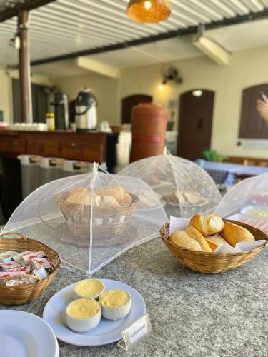 ein Tisch mit Brotkörben und Schüsseln mit Brot in der Unterkunft Paraty CHILL INN Pousada in Paraty