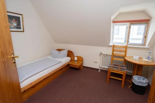 a small room with a bed and a table at Hotel Zur Linde in Meldorf
