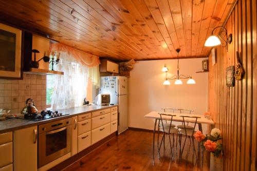 スーズダリにあるGuest House Lybimtsevoyの木製の天井、テーブルと椅子付きのキッチン