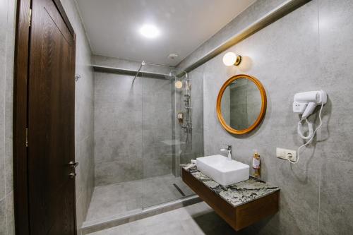 a bathroom with a sink and a shower with a mirror at Gudauri Inn in Gudauri