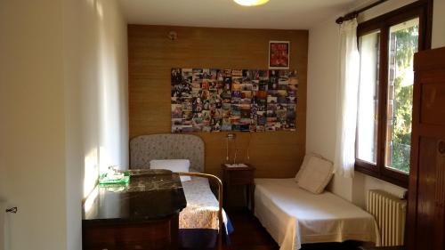 um quarto com uma cama, uma mesa e uma janela em Villa dei Pini em Villorba