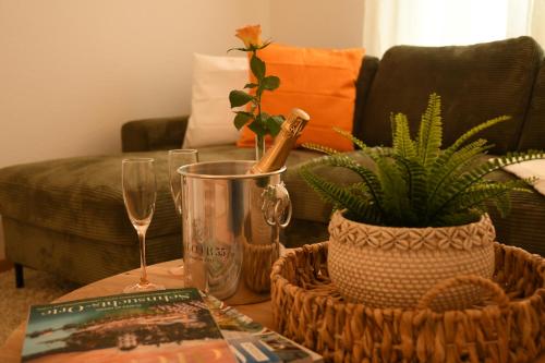 a coffee table with a bottle of champagne and a plant at Engel Apartments in Hard