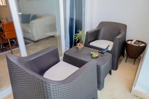 a wicker chair and a table in a living room at Xeliter Cana Rock Punta Cana in Punta Cana