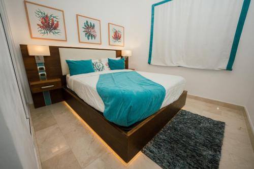 a bedroom with a large bed with blue pillows at Xeliter Cana Rock Punta Cana in Punta Cana