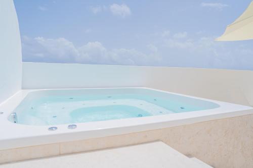 a jacuzzi tub with blue water in a room at Xeliter Cana Rock Punta Cana in Punta Cana