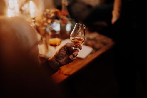 a person holding a glass of wine at a table at Rittergut Positz in Oppurg