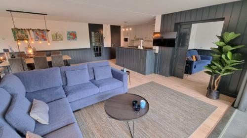 a living room with a blue couch and a table at DSW18 Luxury apartment in the centre with beach cabin in Domburg