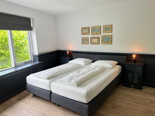 a bedroom with two beds and two windows at DSW18 Luxury apartment in the centre with beach cabin in Domburg