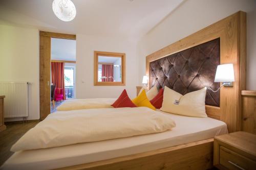 a large bedroom with two beds with colorful pillows at Hotel Friedenseiche in Benediktbeuern