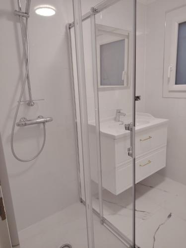 une salle de bain blanche avec une douche et un lavabo dans l'établissement Boulouris entre mer et piscine, à Saint-Raphaël