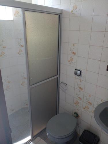 a bathroom with a shower with a toilet and a sink at Pousada da Ale in Ilhéus