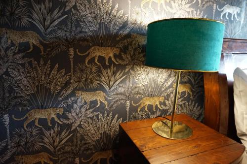 a lamp on a table in a room with a wallpaper at Northern Hideaways Apple Store in Chathill
