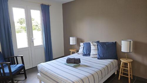 une chambre avec un lit avec des draps bleus et une fenêtre dans l'établissement Grande maison entre Lac et forêt, à Gastes