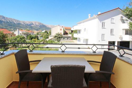 a table and chairs on a balcony with a view at Apartments Gorica 2 in Baška